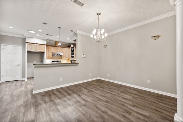 kitchen with an inviting chandelier, a textured ceiling, pendant lighting, light brown cabinetry, and hardwood / wood-style flooring