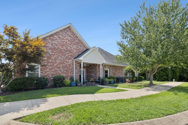 view of front of house with a front lawn and central air condition unit