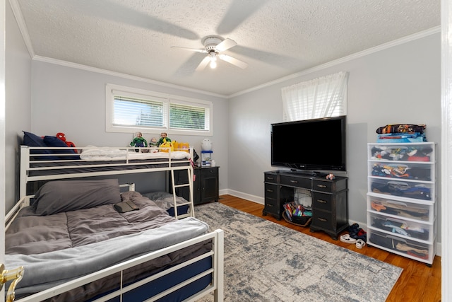 bedroom with ceiling fan, crown molding, wood-type flooring, and a textured ceiling