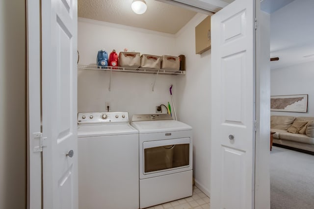 laundry area with crown molding, washer and dryer, and a textured ceiling