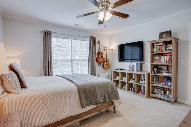 carpeted bedroom with ornamental molding and ceiling fan