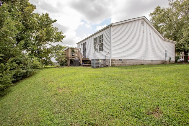 view of property exterior featuring a wooden deck, a yard, and central AC