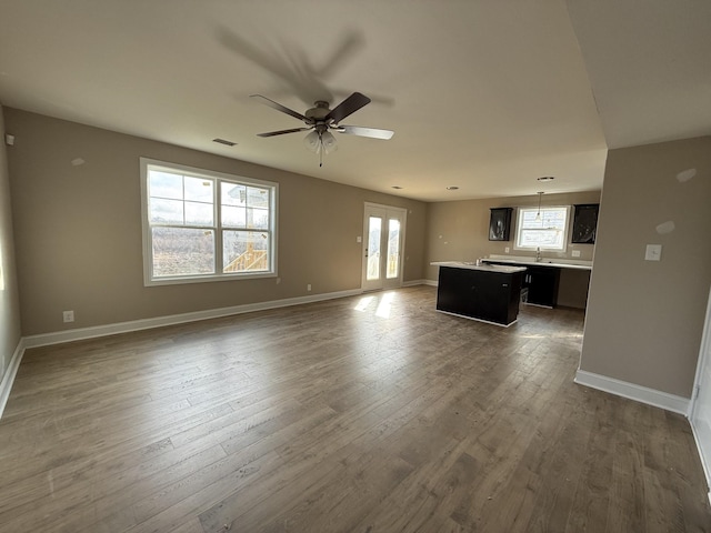 unfurnished living room featuring ceiling fan and dark hardwood / wood-style floors