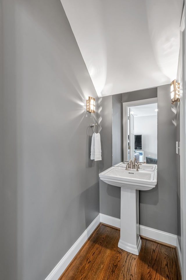 bathroom featuring vaulted ceiling and wood-type flooring