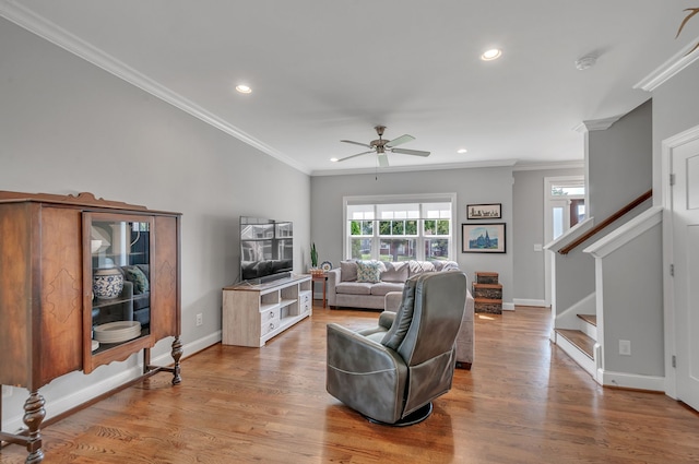 living room with hardwood / wood-style flooring, crown molding, and ceiling fan