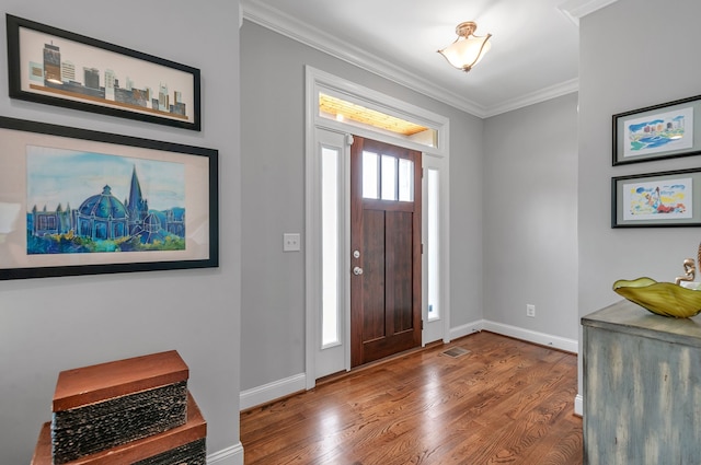 foyer with hardwood / wood-style flooring, plenty of natural light, and crown molding