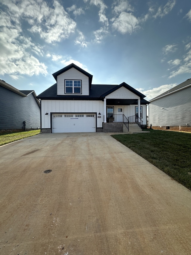 view of front facade featuring a garage, covered porch, and a front yard