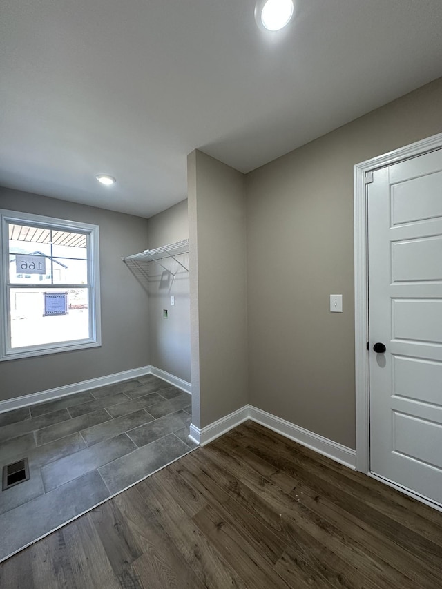 washroom with dark wood-type flooring and hookup for an electric dryer