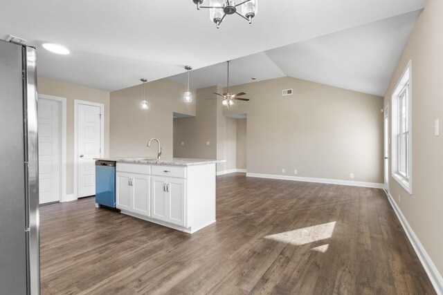 kitchen featuring light stone countertops, vaulted ceiling, stainless steel appliances, a center island with sink, and white cabinets