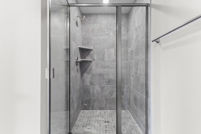 bathroom featuring a shower with door