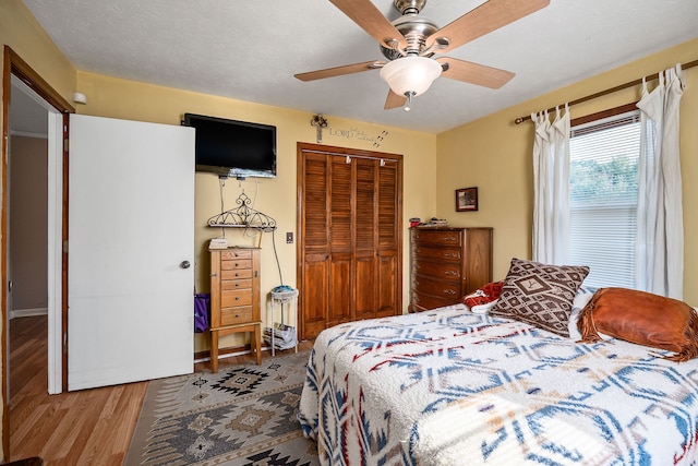 bedroom with ceiling fan, light wood-type flooring, and a closet