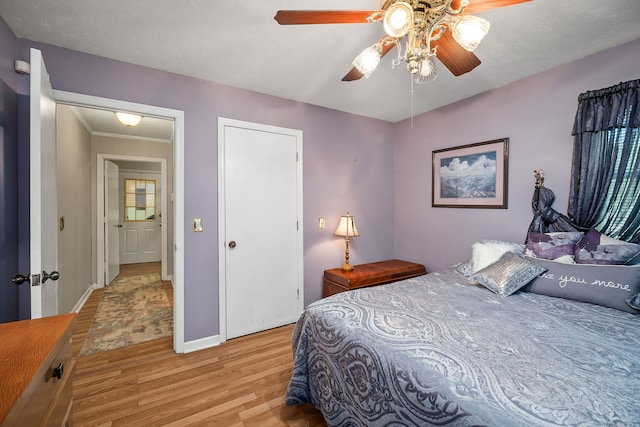 bedroom featuring ceiling fan, a textured ceiling, and light hardwood / wood-style floors