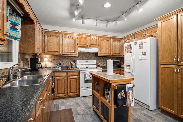 kitchen featuring sink, dark wood-type flooring, white appliances, and decorative backsplash