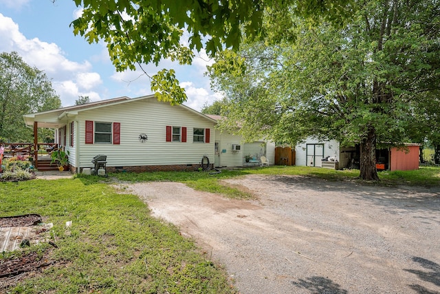 view of front of house featuring a front yard and a shed