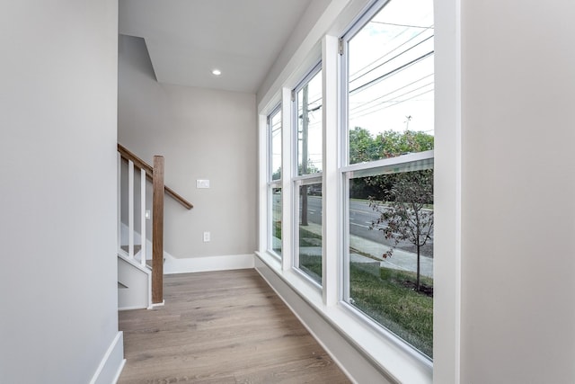 interior space featuring light wood-style floors, recessed lighting, stairway, and baseboards