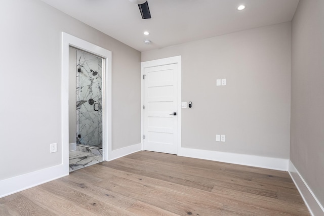 empty room featuring light wood-style floors, baseboards, and recessed lighting