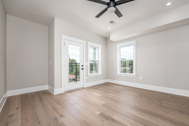 spare room with a healthy amount of sunlight, light hardwood / wood-style floors, and ceiling fan