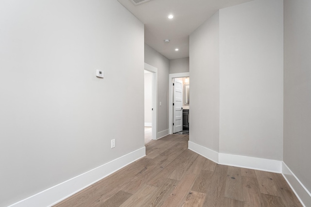 hall with recessed lighting, visible vents, light wood-style flooring, and baseboards