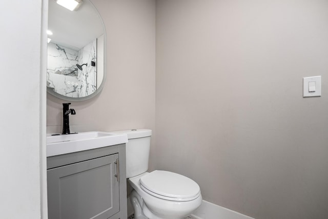 bathroom with baseboards, vanity, and toilet