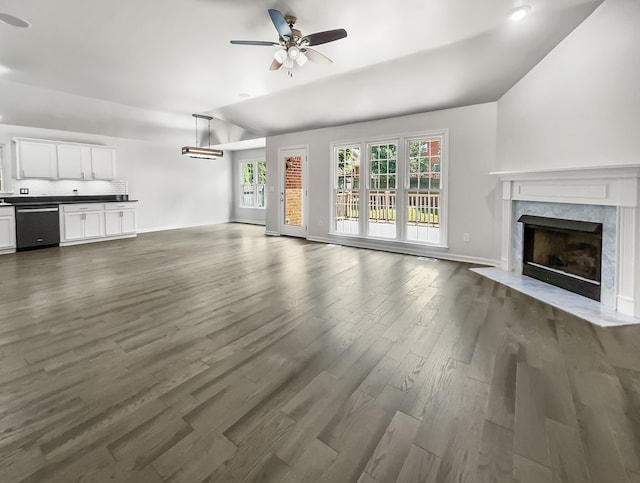 unfurnished living room featuring a premium fireplace, lofted ceiling, dark hardwood / wood-style flooring, and ceiling fan