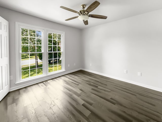 empty room featuring dark hardwood / wood-style flooring, plenty of natural light, and ceiling fan