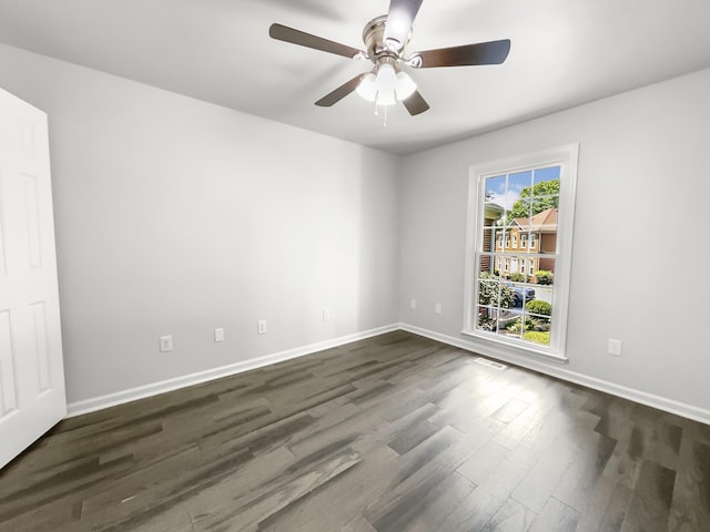 spare room with dark wood-type flooring and ceiling fan