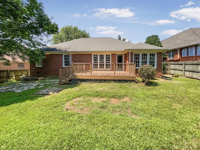 back of property with a yard and a deck