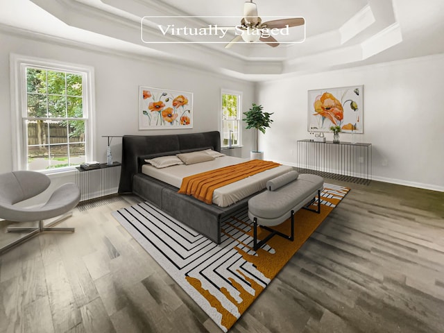 bedroom with hardwood / wood-style flooring, ceiling fan, ornamental molding, and a raised ceiling