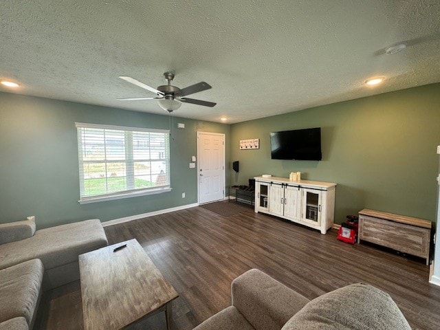 living room with a textured ceiling, dark hardwood / wood-style flooring, and ceiling fan