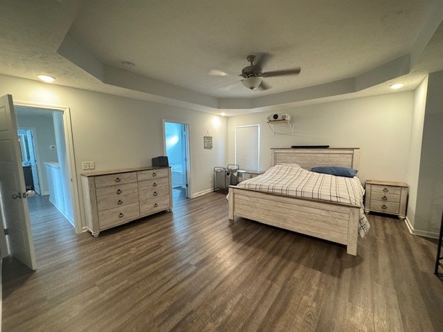 bedroom featuring ceiling fan, a raised ceiling, and dark hardwood / wood-style floors