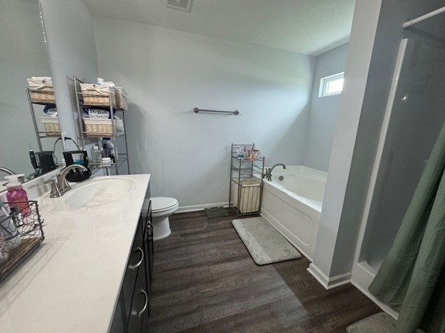 bathroom featuring a tub to relax in, wood-type flooring, vanity, and toilet