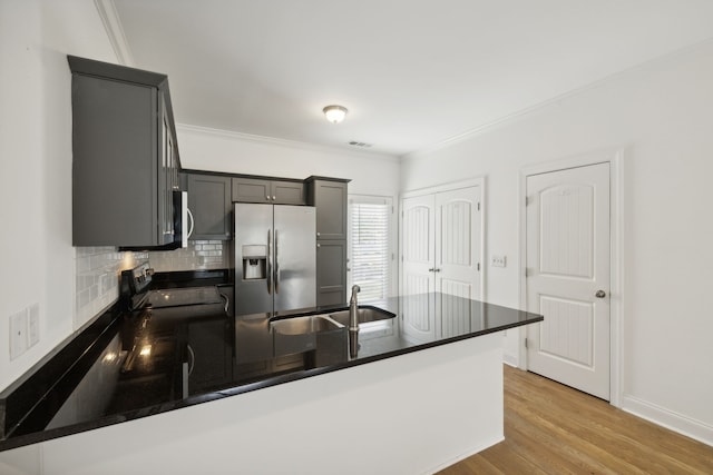 kitchen featuring kitchen peninsula, crown molding, light hardwood / wood-style floors, stainless steel appliances, and sink