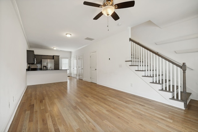 unfurnished living room featuring crown molding, ceiling fan, and light hardwood / wood-style floors