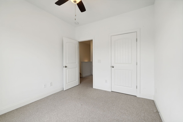 unfurnished bedroom featuring ceiling fan and light colored carpet