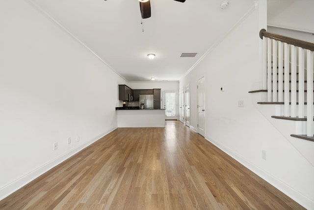 unfurnished living room featuring ceiling fan, ornamental molding, and light hardwood / wood-style floors