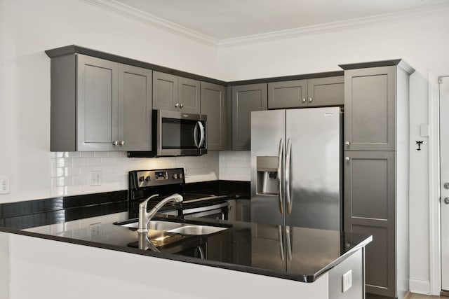 kitchen with appliances with stainless steel finishes, gray cabinets, tasteful backsplash, ornamental molding, and kitchen peninsula