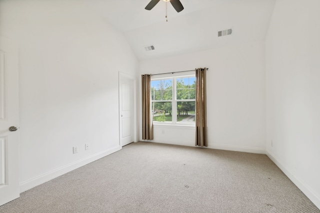 empty room featuring ceiling fan, lofted ceiling, and light carpet