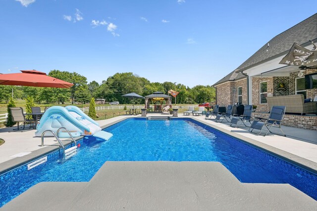 view of pool with a patio area and a water slide