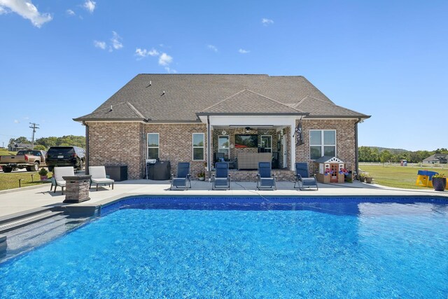 view of swimming pool featuring ceiling fan and a patio