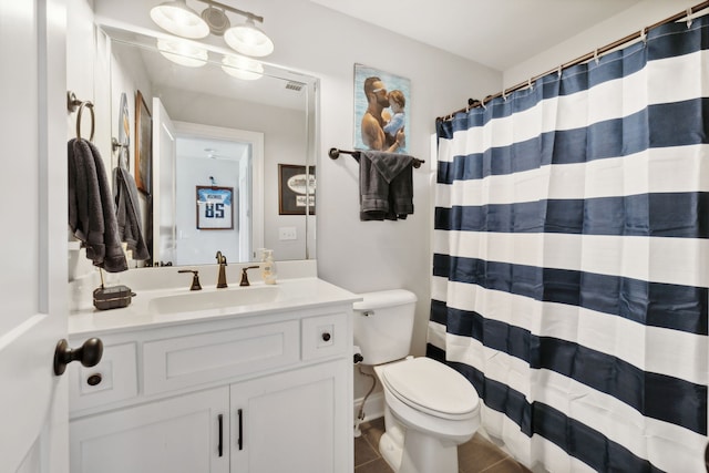 bathroom with tile patterned floors, curtained shower, vanity, and toilet