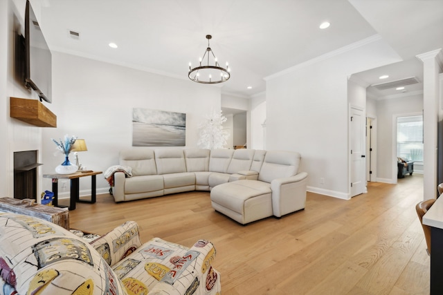 living room with an inviting chandelier, light hardwood / wood-style flooring, and crown molding