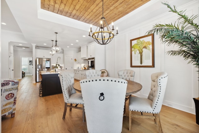 dining space with light hardwood / wood-style flooring, wooden ceiling, sink, a notable chandelier, and crown molding