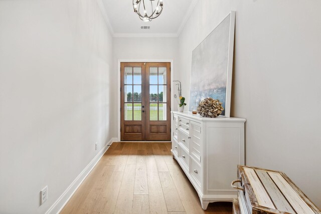 doorway to outside with light hardwood / wood-style floors, crown molding, french doors, and an inviting chandelier