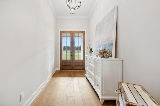 doorway to outside with baseboards, visible vents, light wood-style flooring, crown molding, and french doors