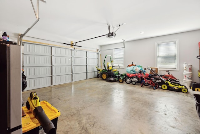 garage featuring a garage door opener and freestanding refrigerator