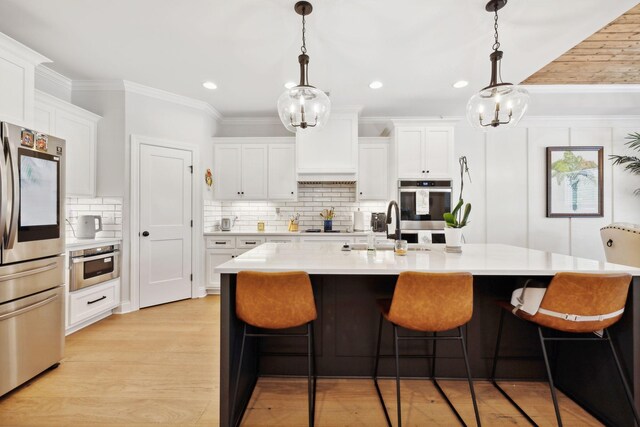 kitchen featuring decorative backsplash, a kitchen breakfast bar, light hardwood / wood-style floors, and stainless steel appliances