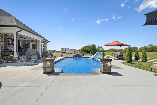 outdoor pool with a water slide, a patio area, fence, and a ceiling fan