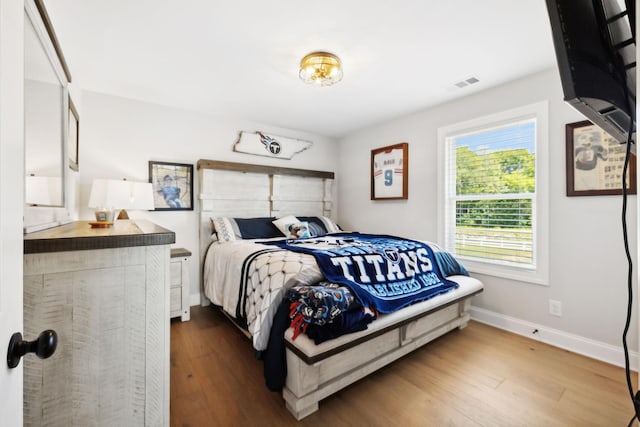 bedroom featuring visible vents, dark wood finished floors, and baseboards