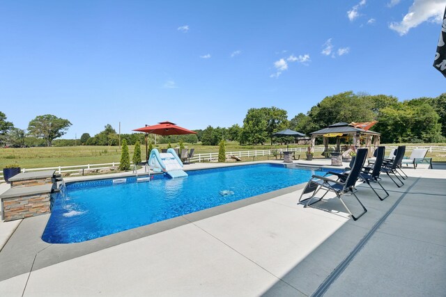 view of swimming pool with a gazebo, a patio, pool water feature, and a water slide