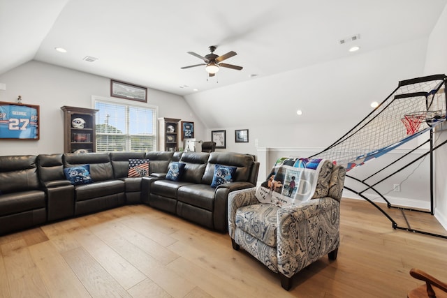 living room with ceiling fan, vaulted ceiling, and light wood-type flooring